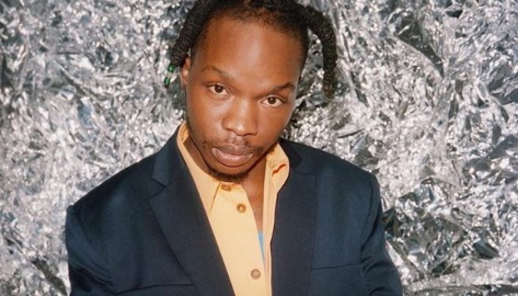 Naira Marley Commends Cameroonian Who Tattooed His Name On Her Chest (Video)