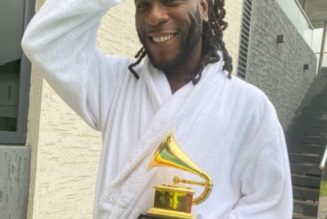 Burna Boy drinks champagne out of his Grammy plaque at the club