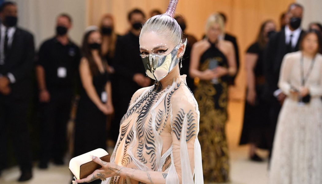 Grimes Says She Trolled Paparazzi by Staging Photo of Herself Reading Karl Marx