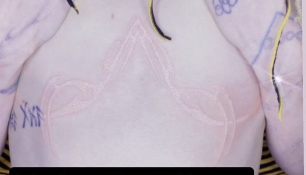 Grimes Shows Off “Post-Human” Chest Tattoo