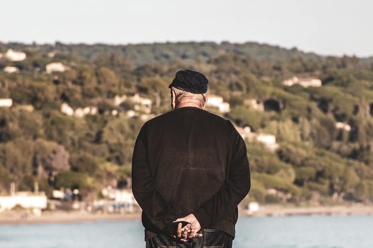 This shows an older man looking over a river