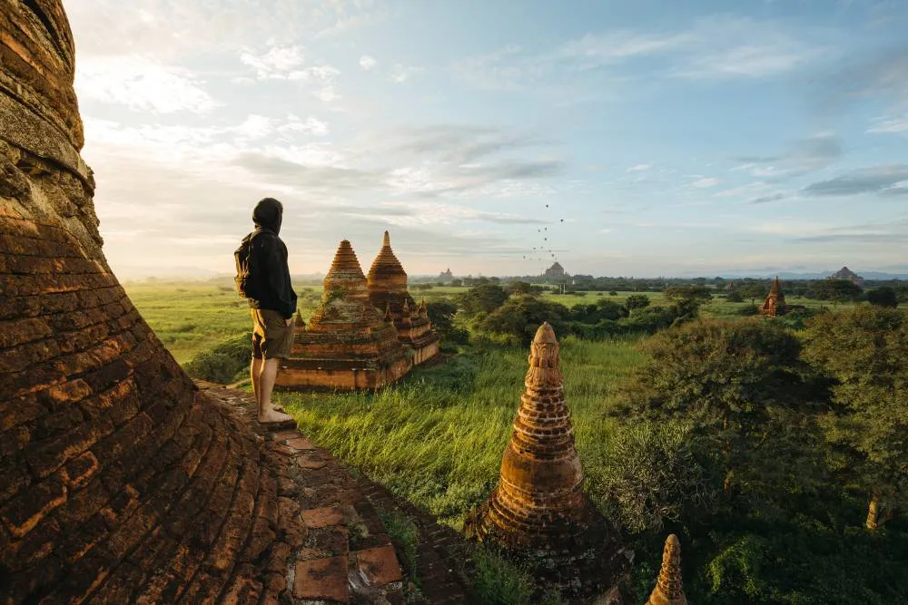 Tourist standing on rural pagoda at sunrise in Myanmar — Getty Images