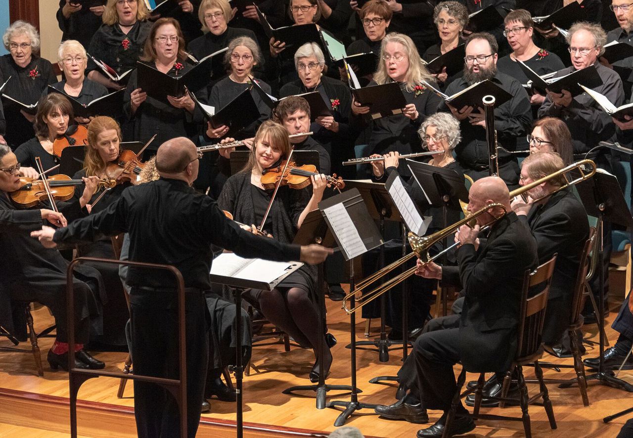 A choir and an orchestra perform on stage.