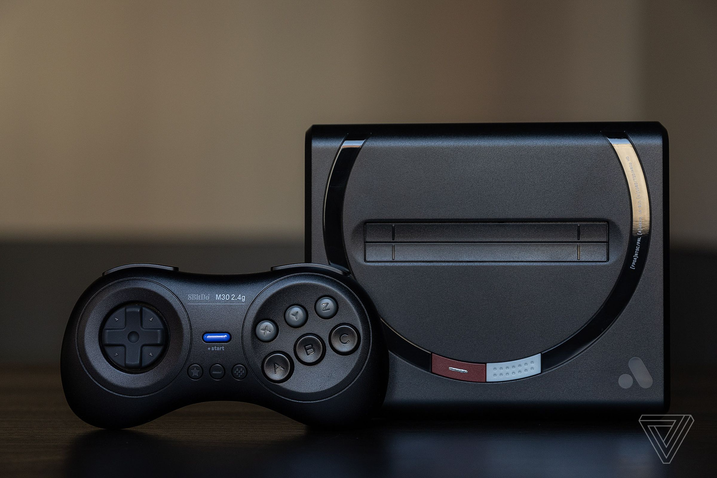 The Sega Genesis-like Analogue Mega Sg console, standing up next to one of its wireless controllers.