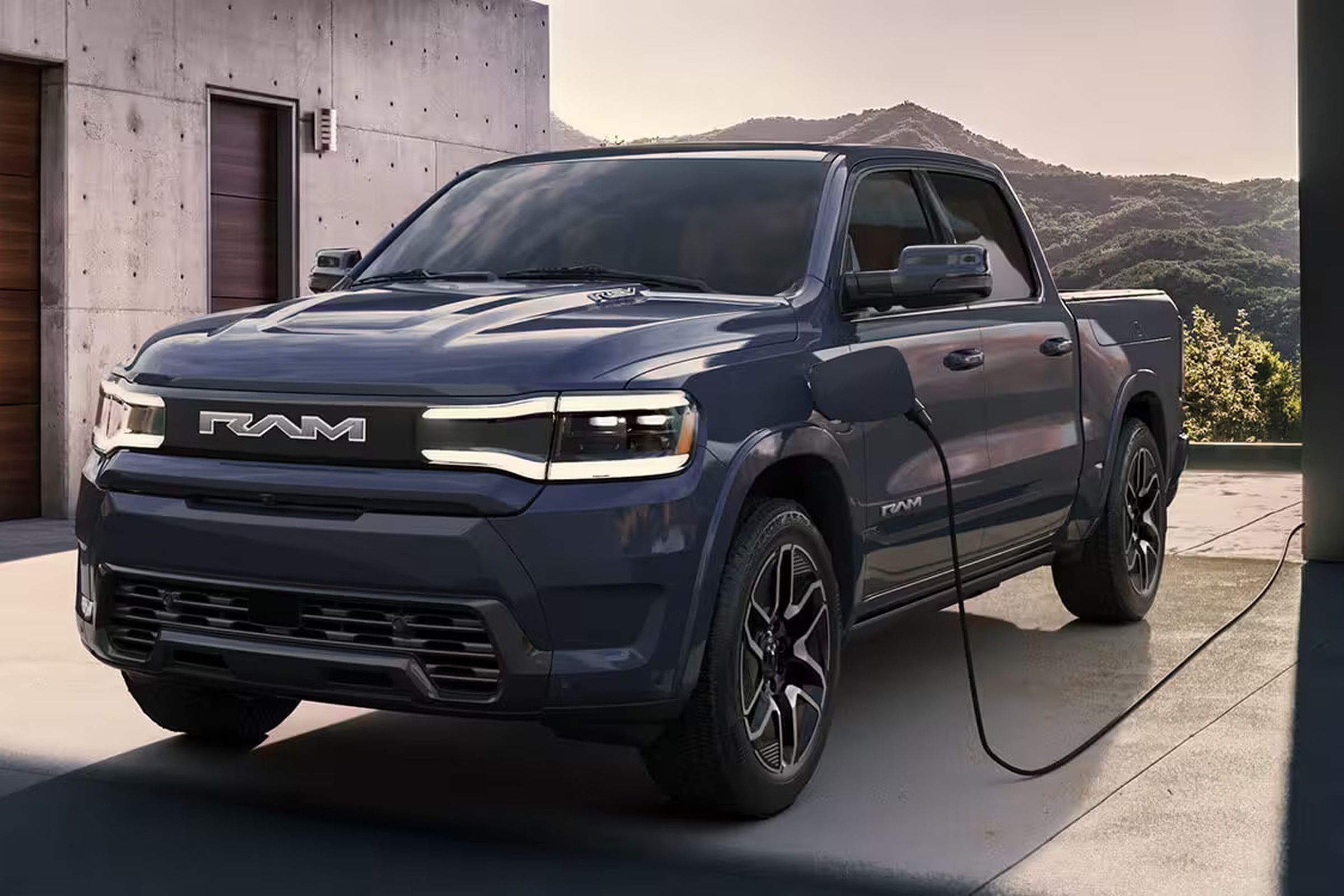 Electric ram truck standing in a modern chic home driveway with a cable plugged into the side.