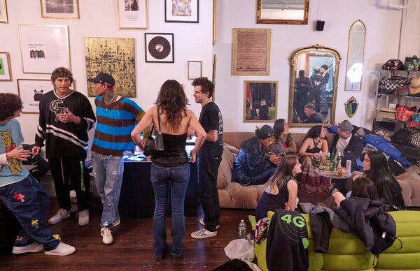 A mix of casually dressed young men and women drinking and chatting in the Ferraro salesroom, which is outfitted with low sofas and walls hung with photos and art. 