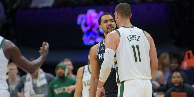 Sacramento Kings forward Trey Lyles, left, and Milwaukee Bucks center Brook Lopez, #11, argue in the final seconds of the second half of an NBA basketball game in Sacramento, California, Monday, March 13, 2023.