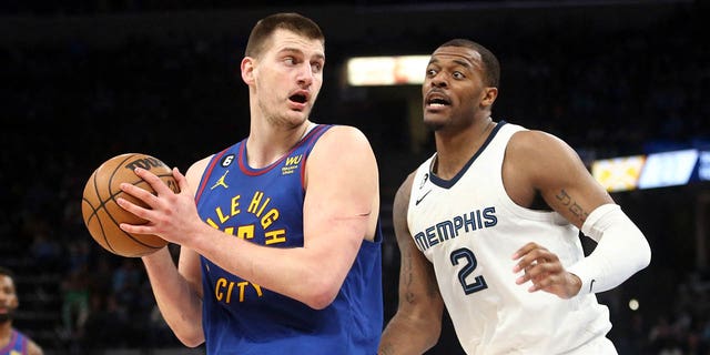 Denver Nuggets center Nikola Jokic (15) spins toward the basket as Memphis Grizzlies forward Xavier Tillman (2) defends during the first half at FedEx Forum in Memphis Feb 25, 2023.