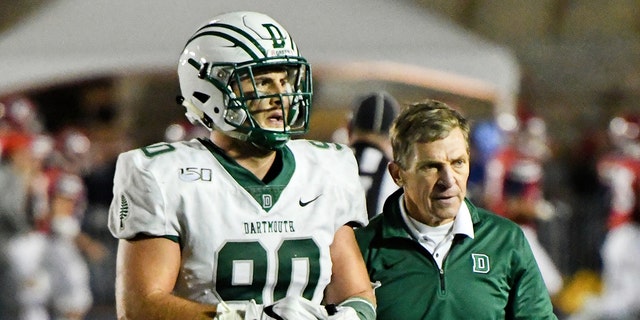 Dartmouth Big Green head coach Buddy Teevens walks with Dartmouth Big Green defensive end Niko Lalos (90) during the game between the Penn Quakers and the Dartmouth Big Green on October 4, 2019 at Franklin Field in Philadelphia, PA.