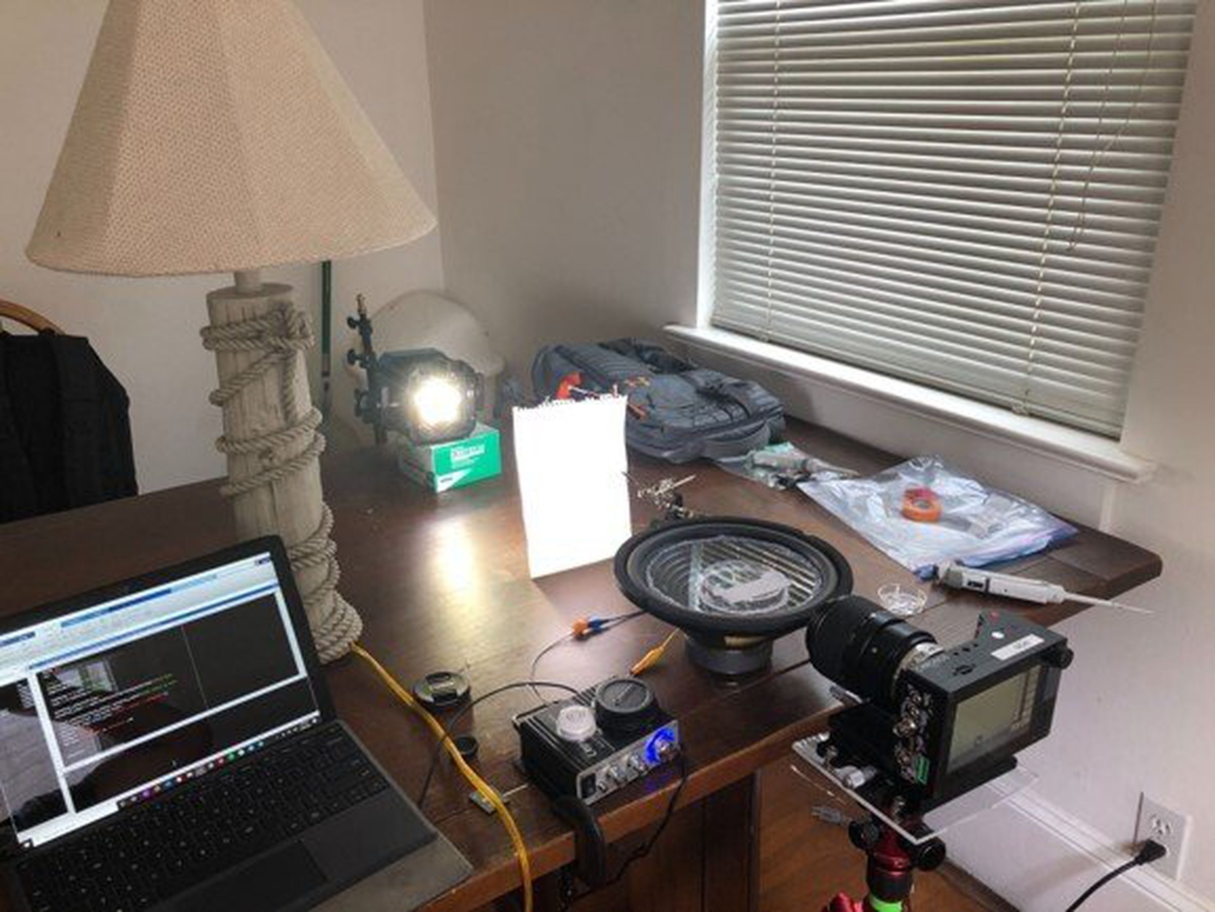 A speaker set up on a kitchen table with a camera recording it.