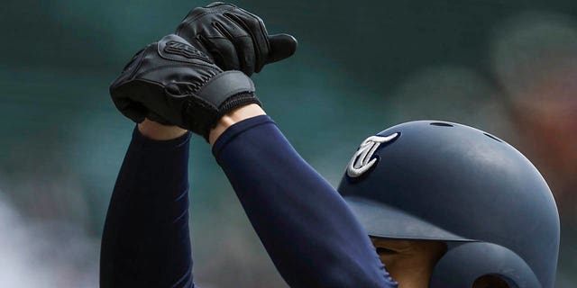 A player for Tohoku High School gestures after getting on first base during their game against Yamanashi Gakuin Senior High School at a stadium in Nishinomiya, Osaka, western Japan, Saturday, March 18, 2023.