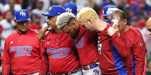 Edwin Diaz of Team Puerto Rico is helped off the field after sustaining an injury while celebrating a 5-2 win against Team Dominican Republic during their World Baseball Classic Pool D game at loanDepot park on March 15, 2023, in Miami, Florida.