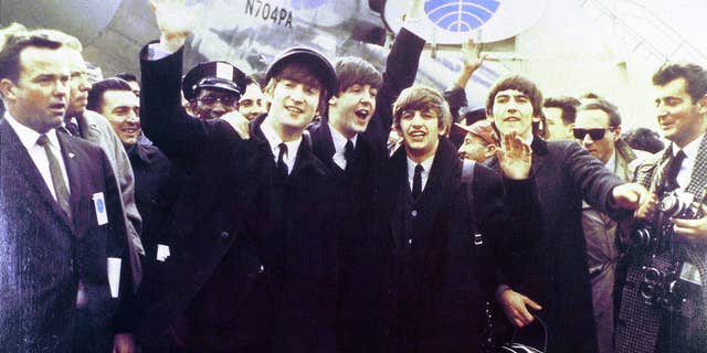 From left to right, John Lennon, Paul McCartney, Ringo Starr and George Harrison wave at crowds arriving at JFK airport for first U.S. tour.