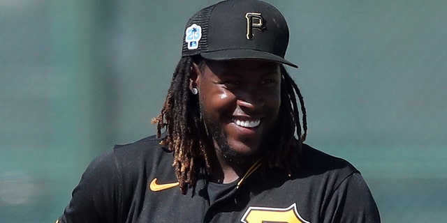 Pittsburgh Pirates Shortstop Oneil Cruz (15) smiles after looking over towards the runner on second base during the spring training game between the Philadelphia Phillies and the Pittsburgh Pirates on February 27, 2023, at LECOM Park in Bradenton, FL.