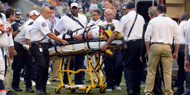 Denver Broncos defensive end Derek Wolfe (95) gets looked at by the medical staff after suffering an injury in the first quarter against the Seattle Seahawks August 17, 2013, at CenturyLink Field. Wolfe was put on an ambulance and taken to the hospital. 