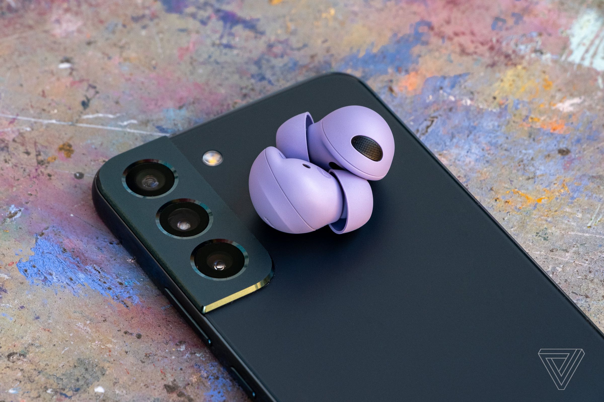 A pair of Samsung’s new Galaxy Buds 2 Pro sitting on top of a phone.