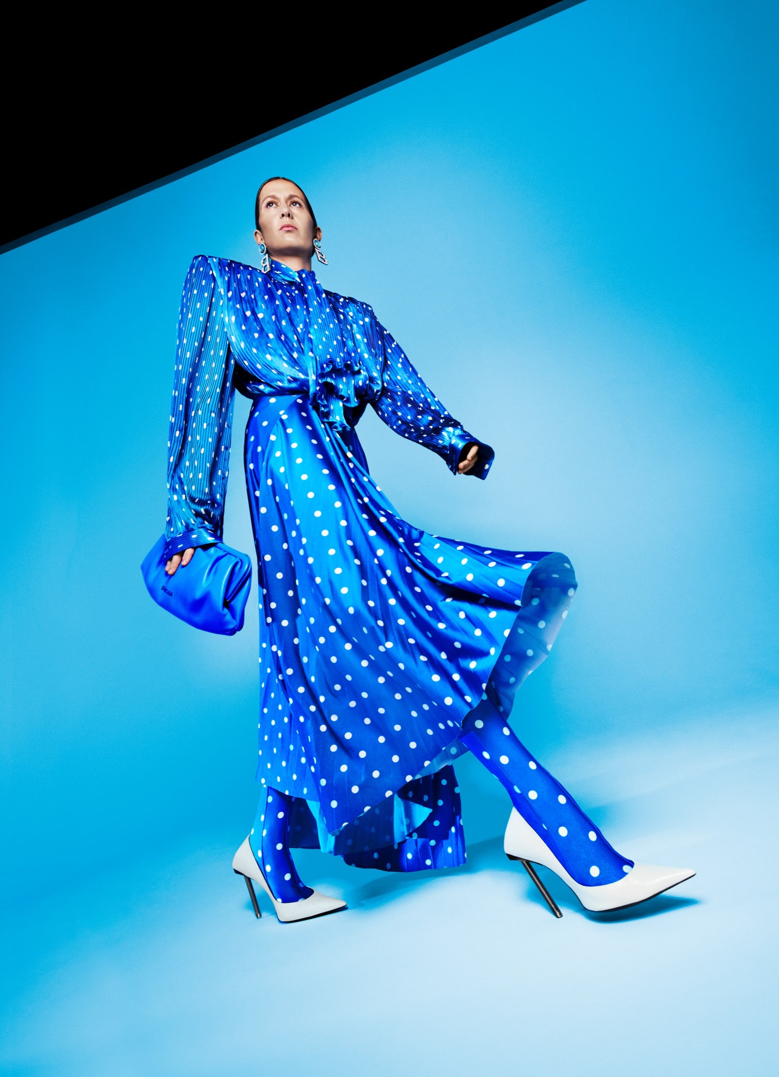 A model poses in a blue dress with white polkadots.