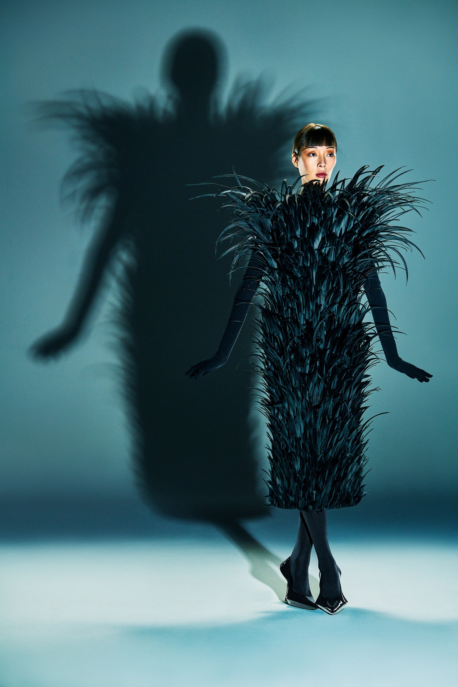 A model poses in a feathered dress.