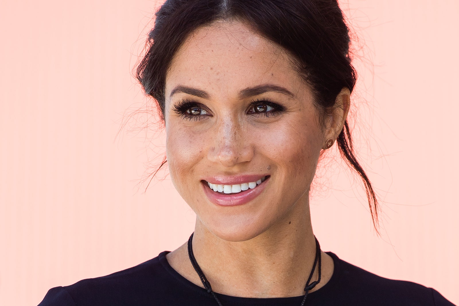 Meghan Markle vor einem rosafarbenen Hintergrund