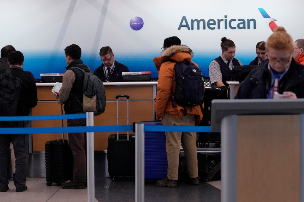 Travelers check in at an American Airlines ticket counter.