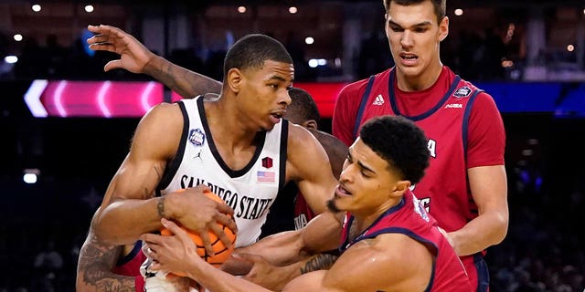 San Diego State forward Keshad Johnson, left, and Florida Atlantic guard Bryan Greenlee, right, scramble for the ball during the first half of a Final Four game in the NCAA Tournament Saturday, April 1, 2023, in Houston. 