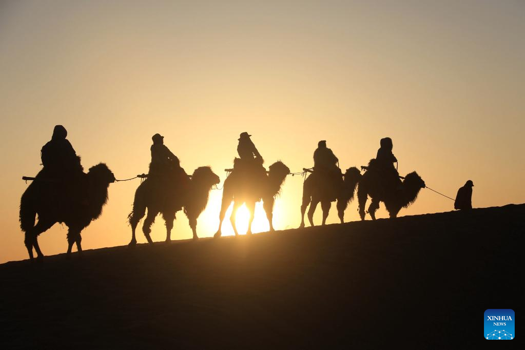 People visit the Mingsha Mountain and Crescent Spring scenic spot in Dunhuang, northwest China's Gansu Province, April 29, 2023. /Xinhua