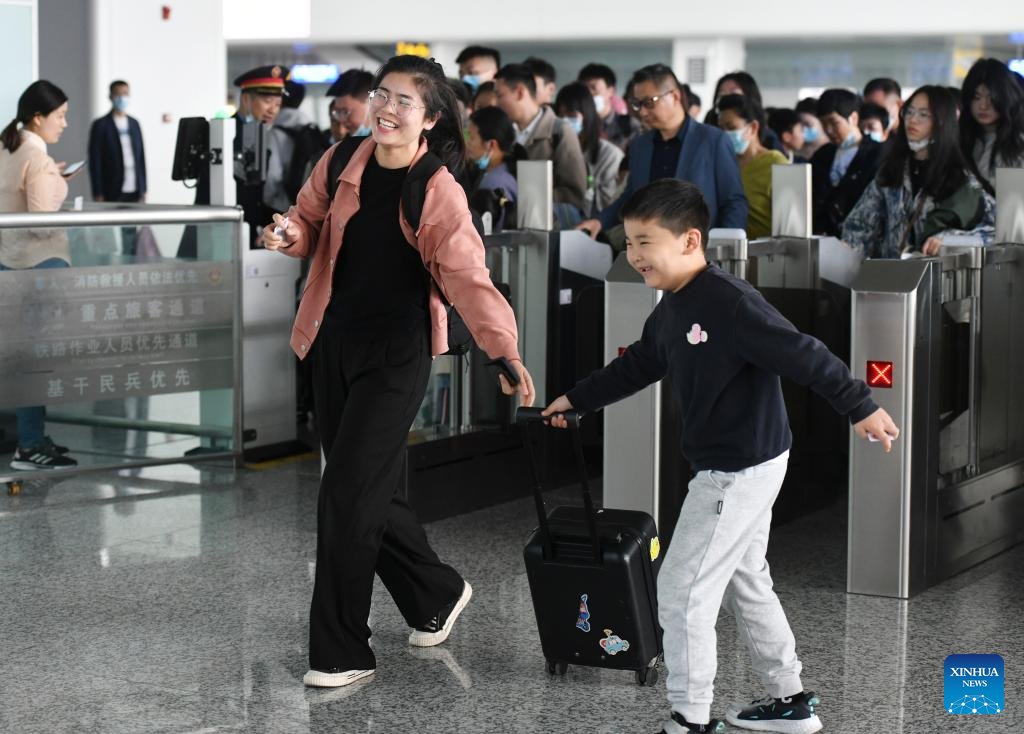 Passengers get their tickets checked before boarding a train at Fuyang West Railway Station in Fuyang City, east China's Anhui Province, April 29, 2023. /Xinhua