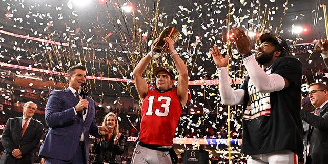 Stetson Bennett holds up the championship trophy