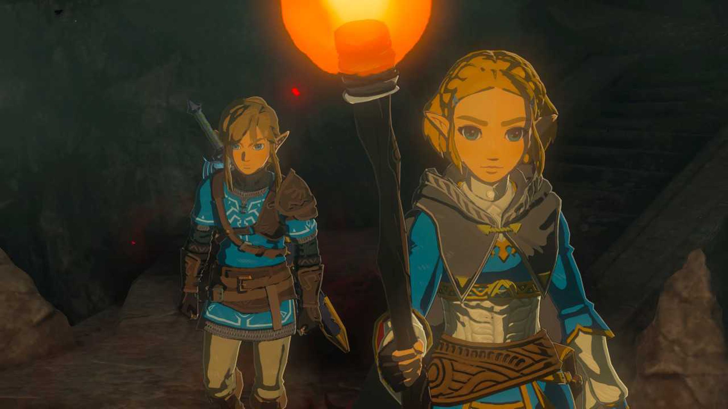 Screenshot from Tears of the Kingdom featuring Link and Zelda exploring a dark, torchlit cave