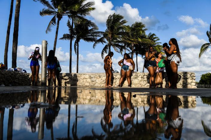 Tourists rinse their feet after getting out of the ocean in Miami Beach in 2021.