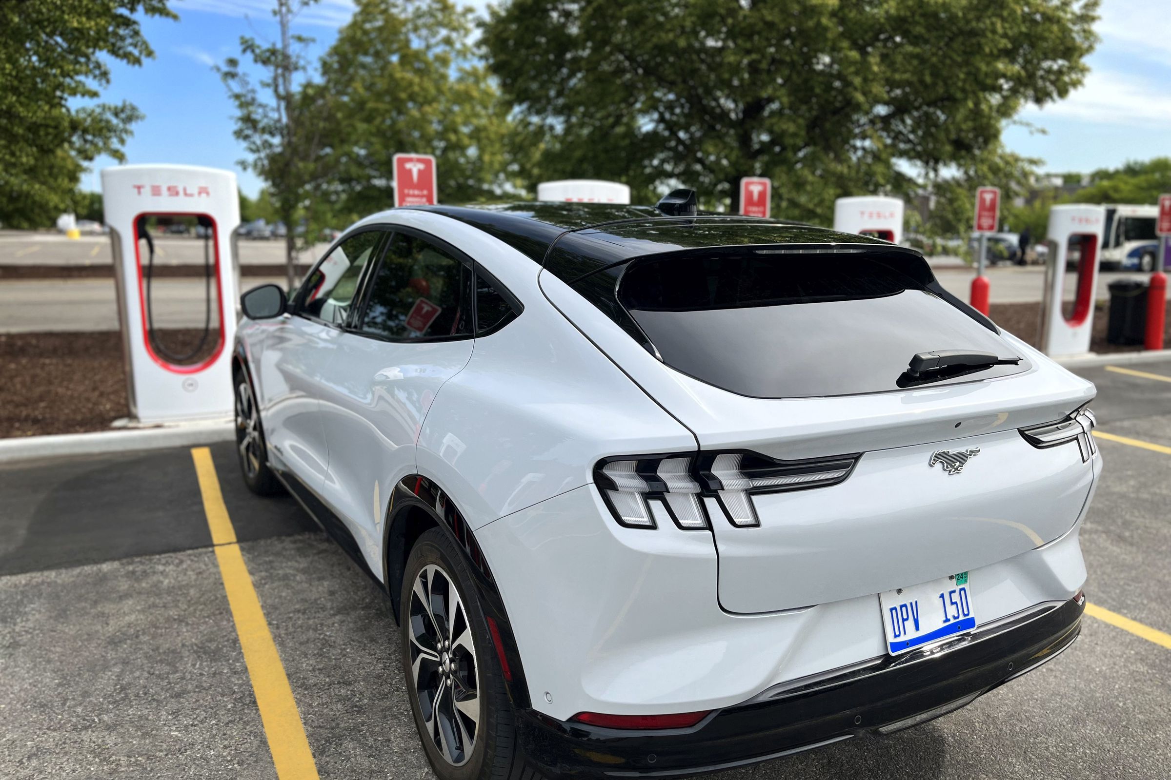 A Ford Mustang Mach-E sitting at a Tesla Supercharger