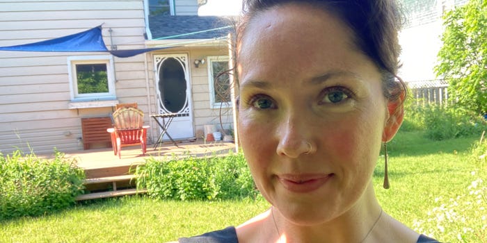 allison nichol longtin in her backyard with grass and her home behind her