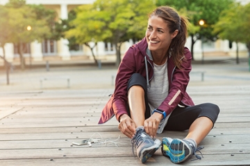 Female runner ties her shoe