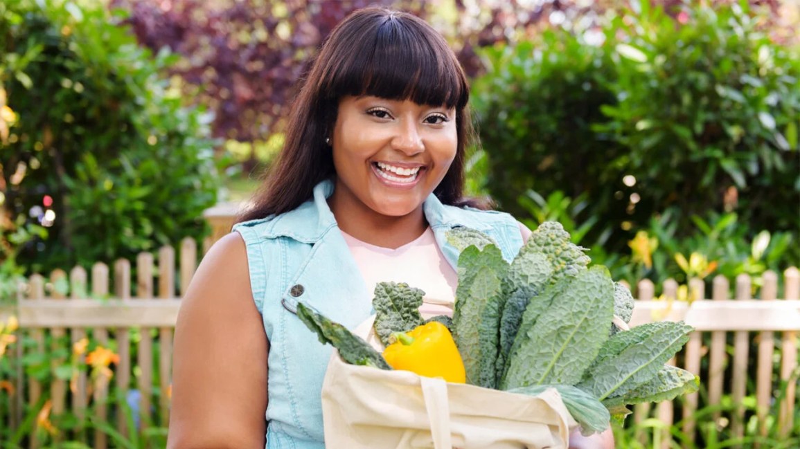 A woman holding a bag of groceries. 