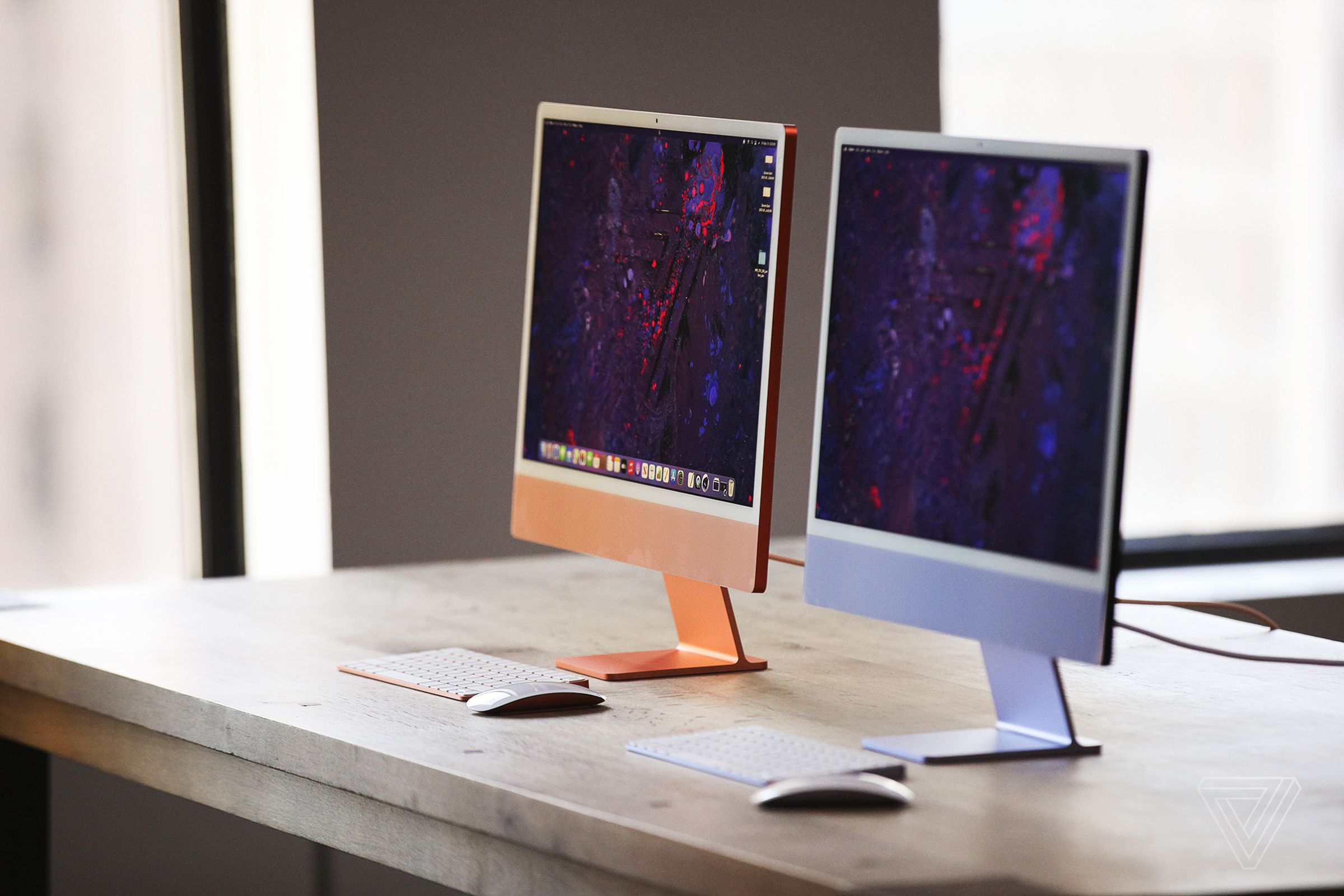 Orange and purple M1 iMacs side by side