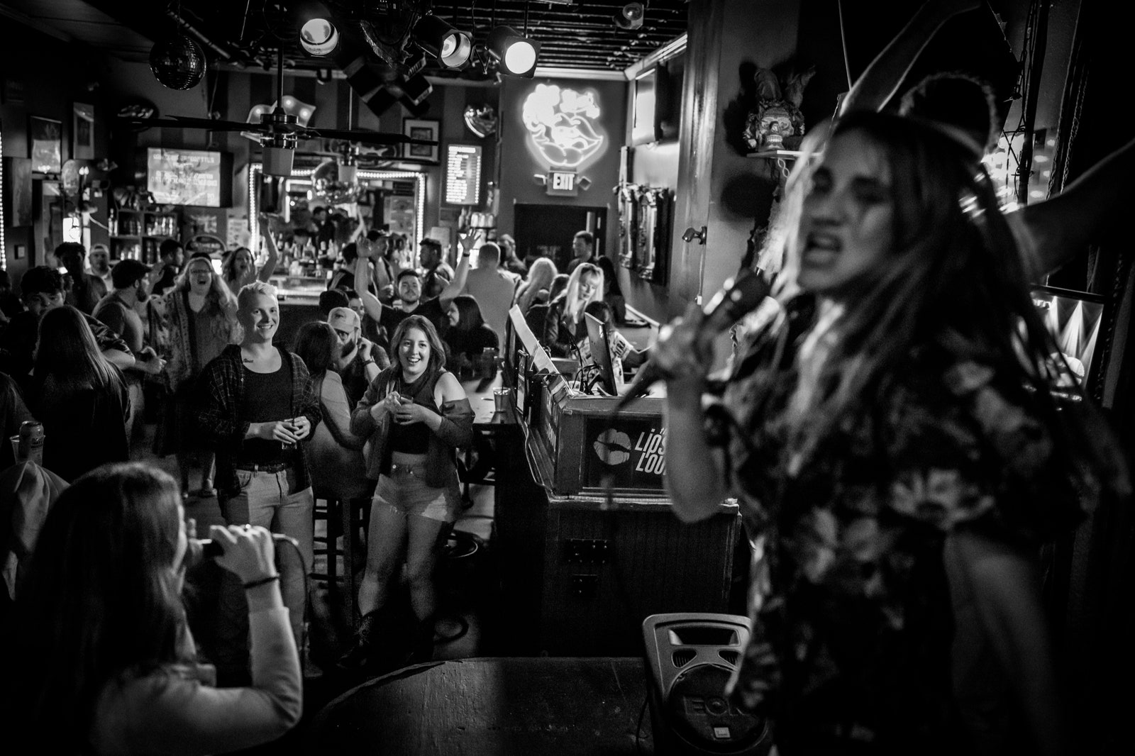 People sing into microphones at the Lipstick Lounge.