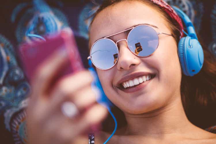 Attractive young woman listening to music on her smart phone