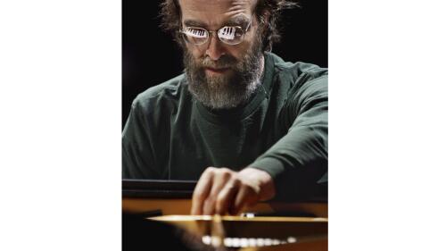 FILE - George Winston makes an adjustment on his piano during a sound check before his performance at the Cerritos Center for the Performing Arts in Cerritos, Calif., on Nov. 4, 2004. (AP Photo/Reed Saxon, File)