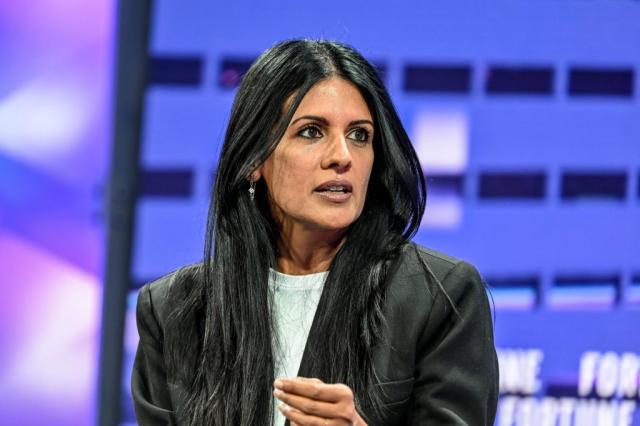 Woman wearing a suit jacket speaking onstage