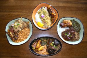 Four East African dishes including rice, beans, meats and vegetables.