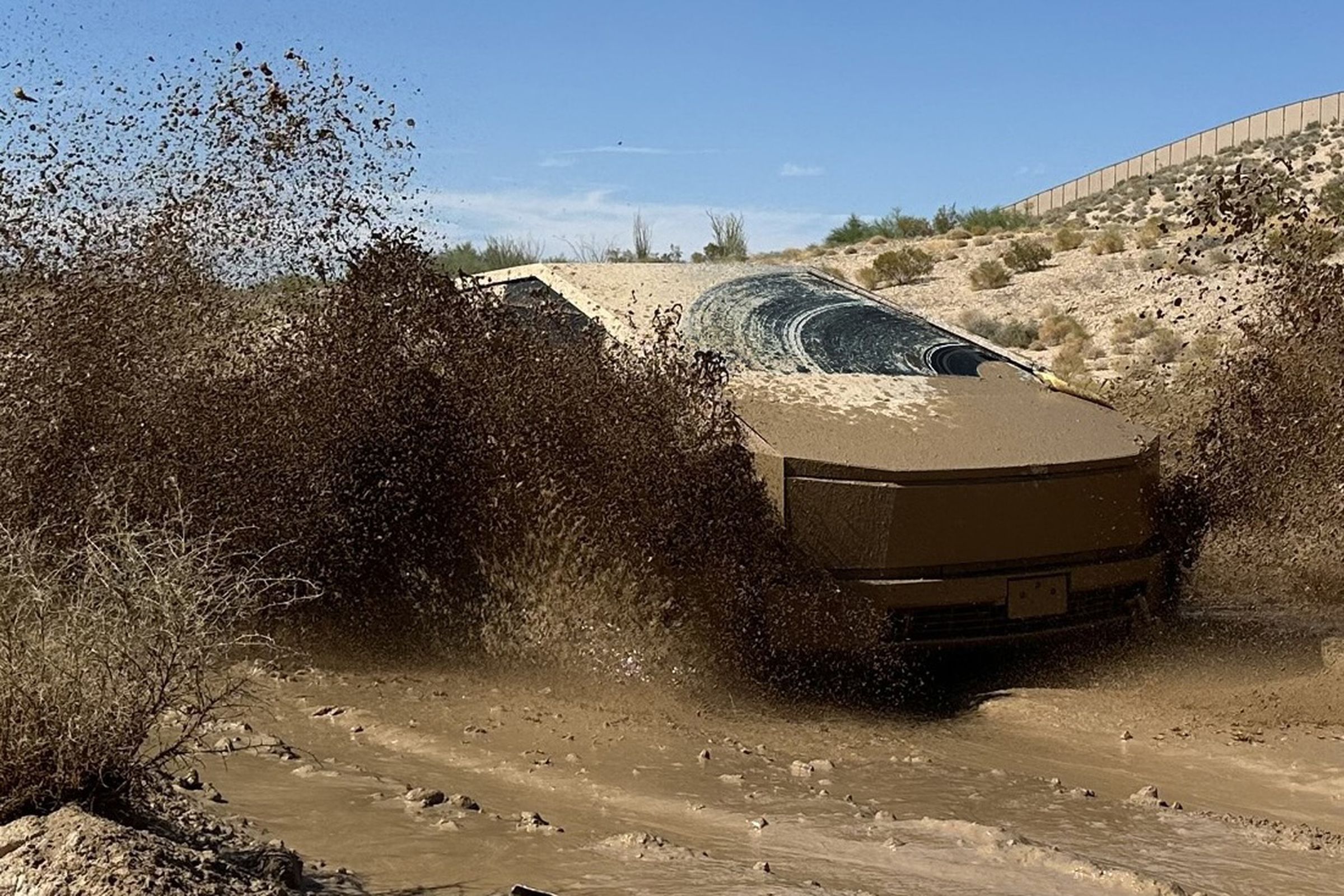 muddy cybertruck launching wet dirt from all tires