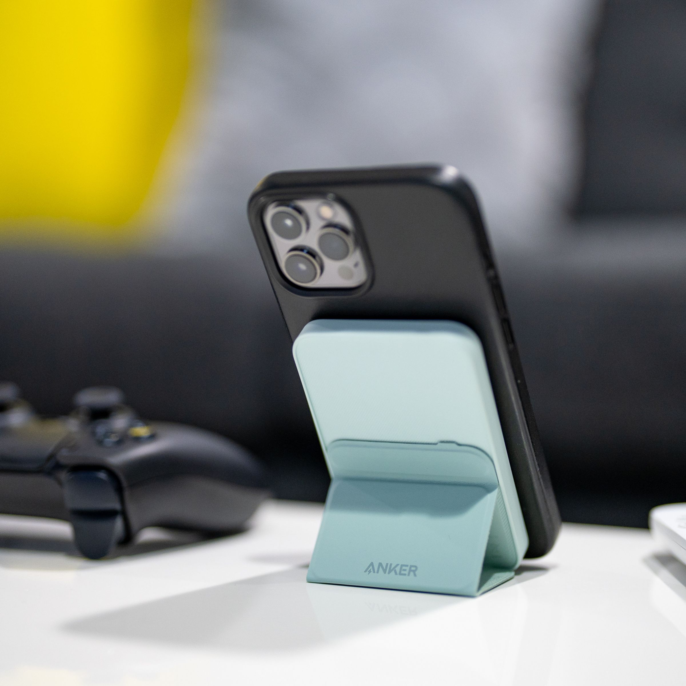 Anker’s 622 Magnetic Battery (MagGo) holding up an iPhone with its kickstand on a desk.