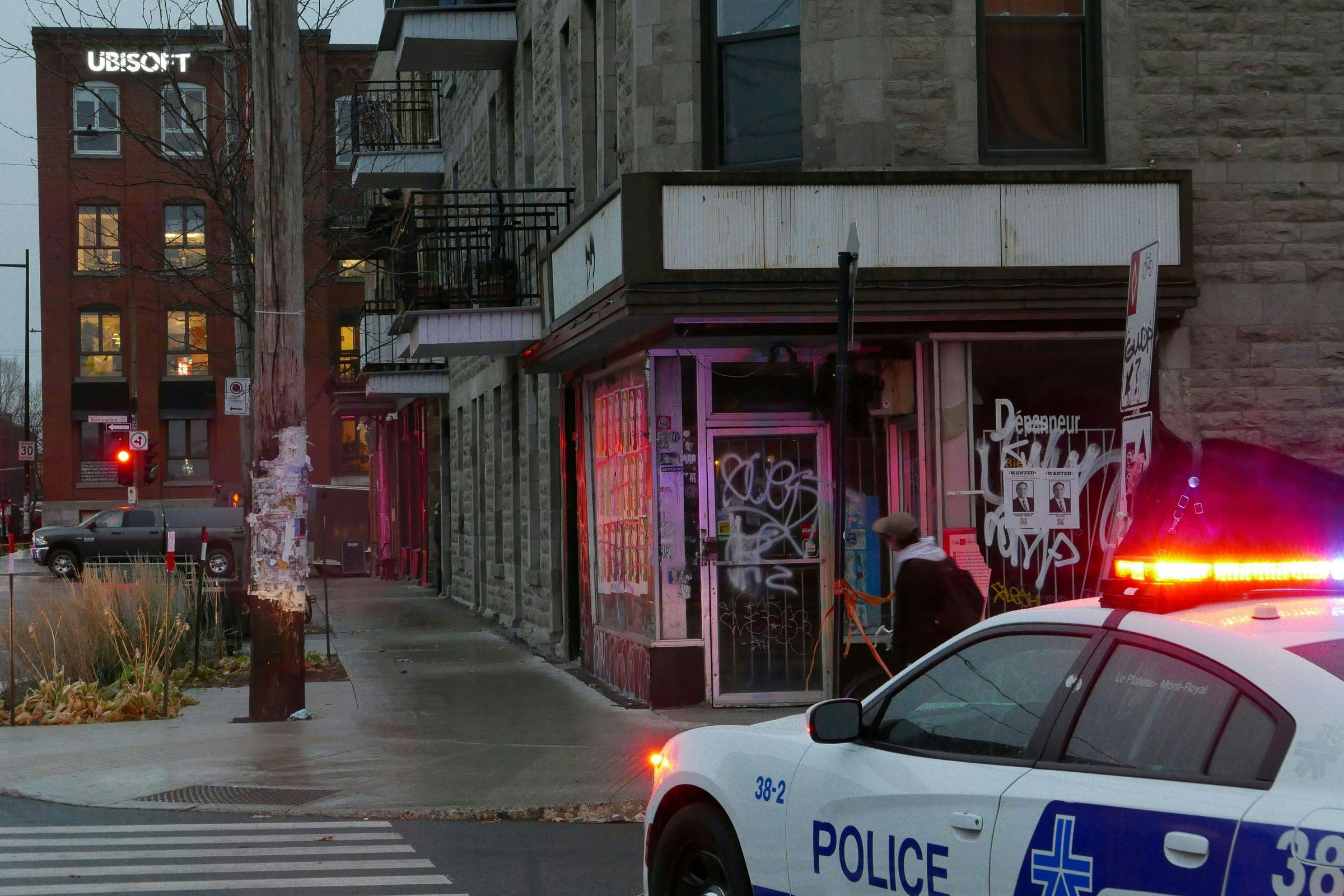 A police car sits a block away from the Ubisoft Montreal office building in the late evening.