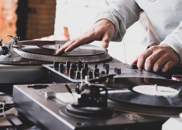 DJ playing music at a hip hop party. analog turntable, Dj uses turntable and mixer for scratching.