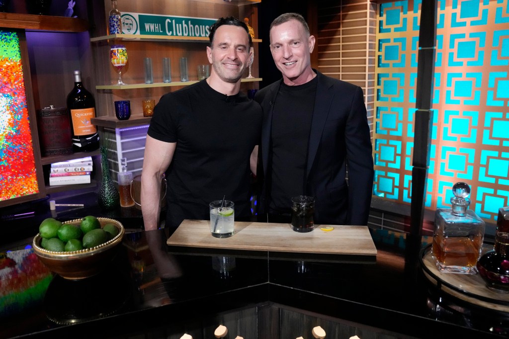 Photo of two men smiling at a bar. 