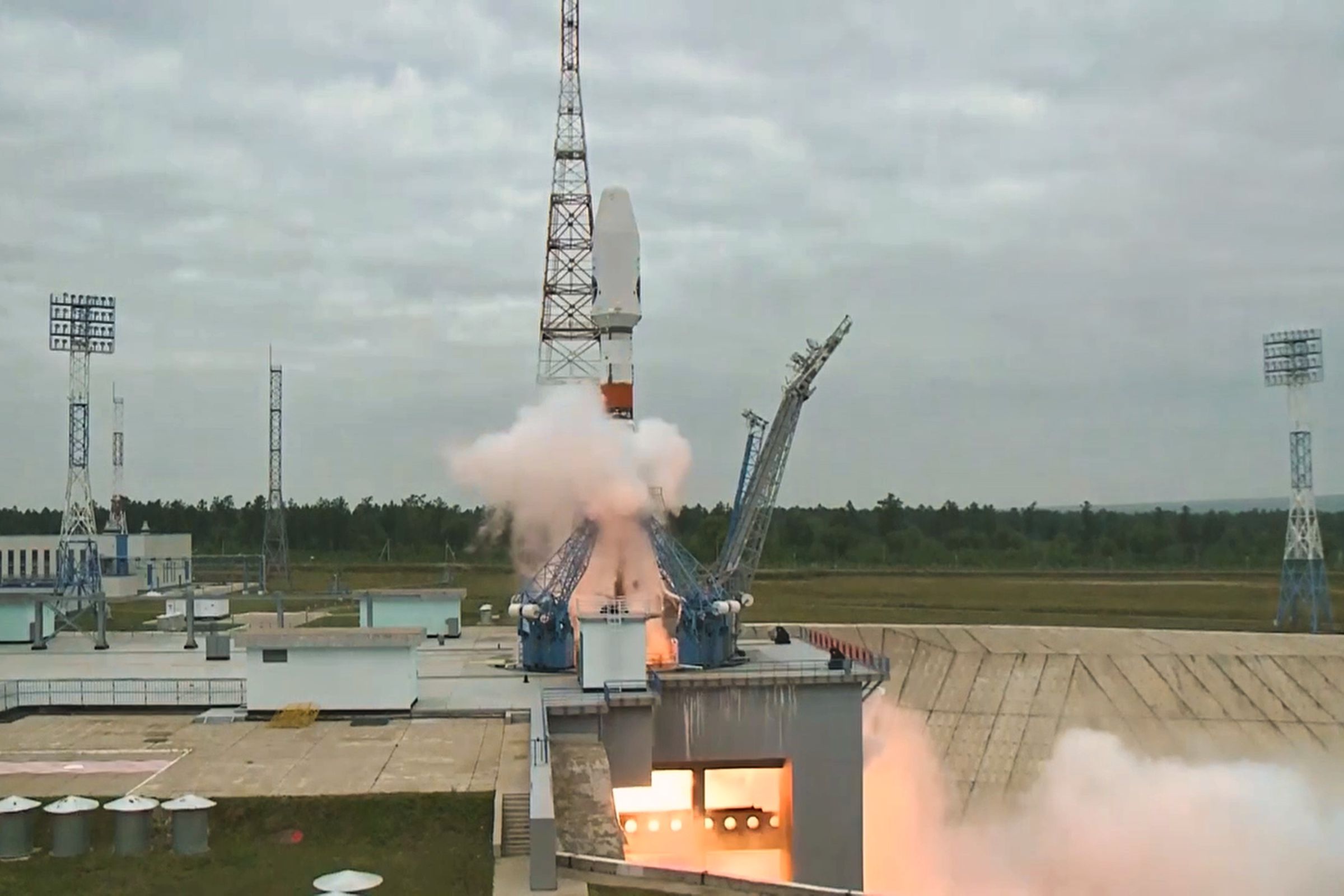 A picture of a rocket just as it begins to launch on a cloudy day.