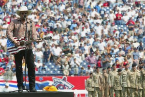 NASHVILLE, TN - SEPTEMBER 8: Recording artist Toby Keith sings with armed service members behind him on the field before the NFL game between the Philadelphia Eagles and the Tennessee Titans on September 8, 2002 at the Coliseum in Nashville, Tennessee. The Titans defeated the Eagles 27-24. (Photo by Elsa/Getty Images)