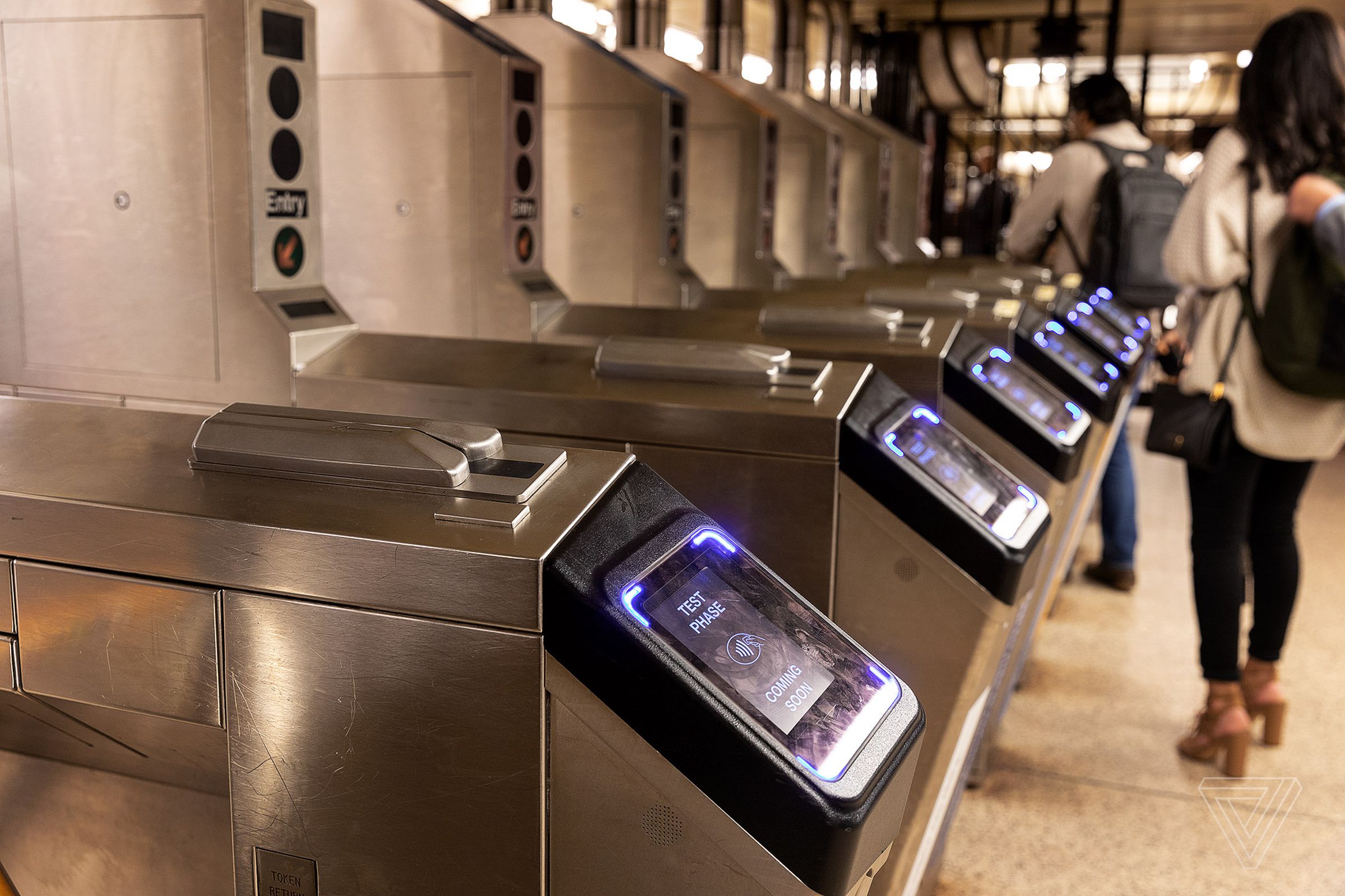 A bank of subway turnstiles with NYC’s OMNY scanners