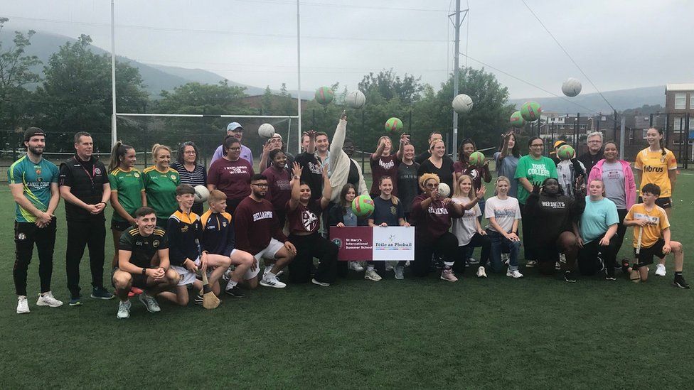 A group shot of the students with some of Antrim's Gaelic football development squad on the pitch