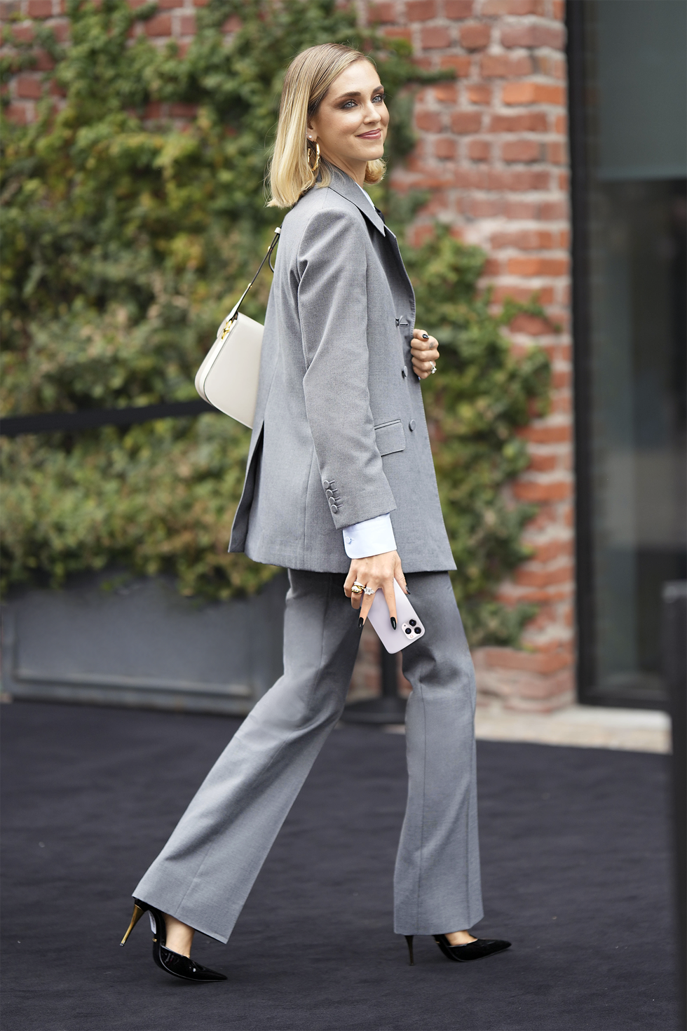 milan, italy february 24 chiara ferragni wears gold earrings, a white shirt, a black tie, a pale blue shirt, black lace print pattern transparent micro shorts, a gray blazer jacket, matching suit legs, a beige shiny leather shoulder bag from gucci, black shiny leather pointed pumps heels shoes, diamonds rings , outside gucci, during the milan fashion week womenswear fallwinter 20232024 on february 24, 2023 in milan, italy photo by edward berthelotgetty images